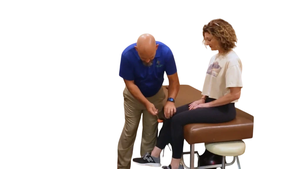Dr. Micah Carter testing knee reflexes for new female chiropractic patient