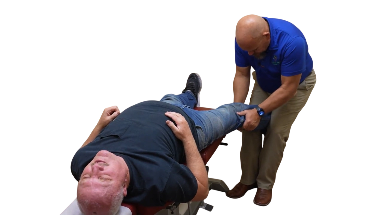 Dr. Micah Carter performing a knee adjustment on a male chiropractic patient