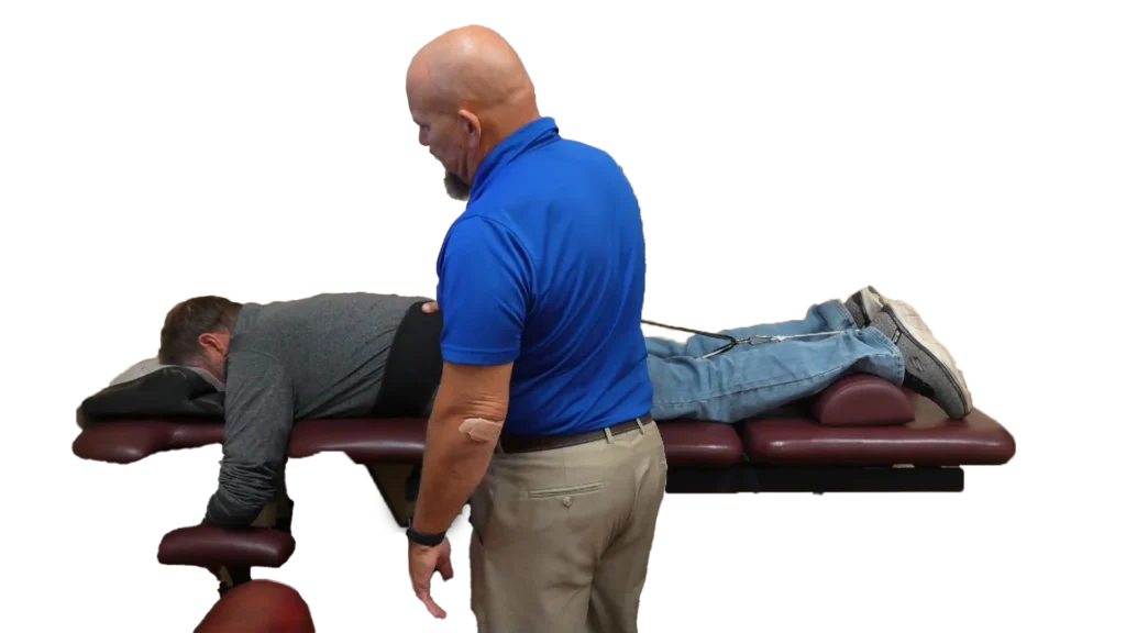 Spinal decompression machine with male chiropractic patient laying on adjustment table