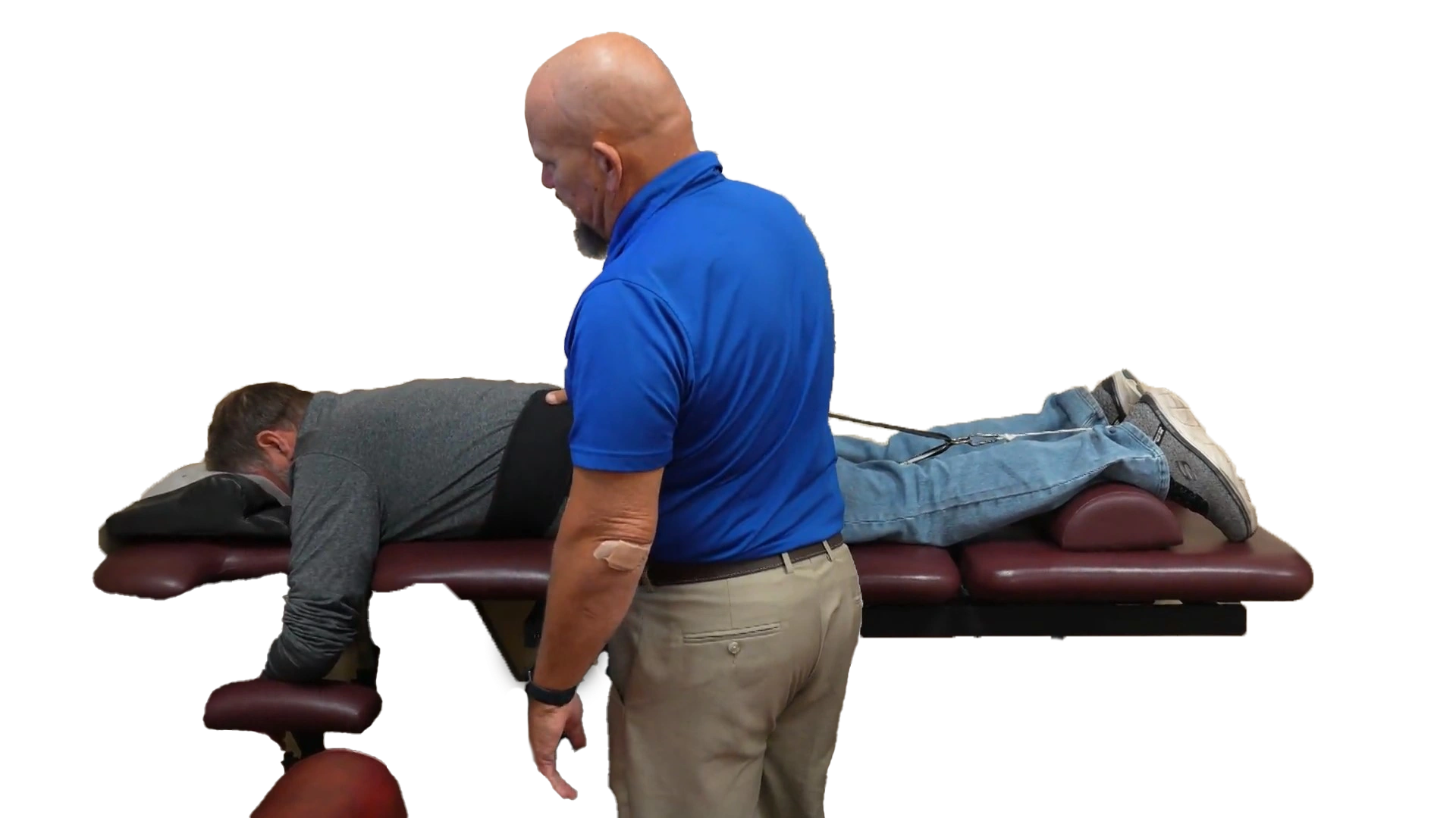 Spinal decompression machine with male chiropractic patient laying on adjustment table