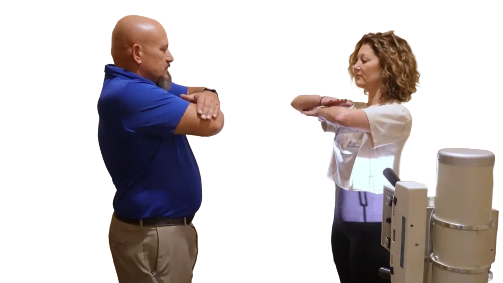Dr. Micah Carter showing female patient how to stand for spinal xrays