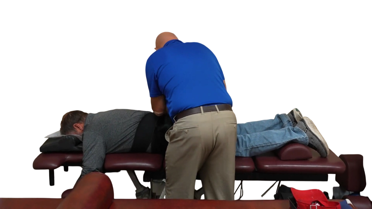 Dr. Micah Carter setting up a male patient on spinal decompression machine
