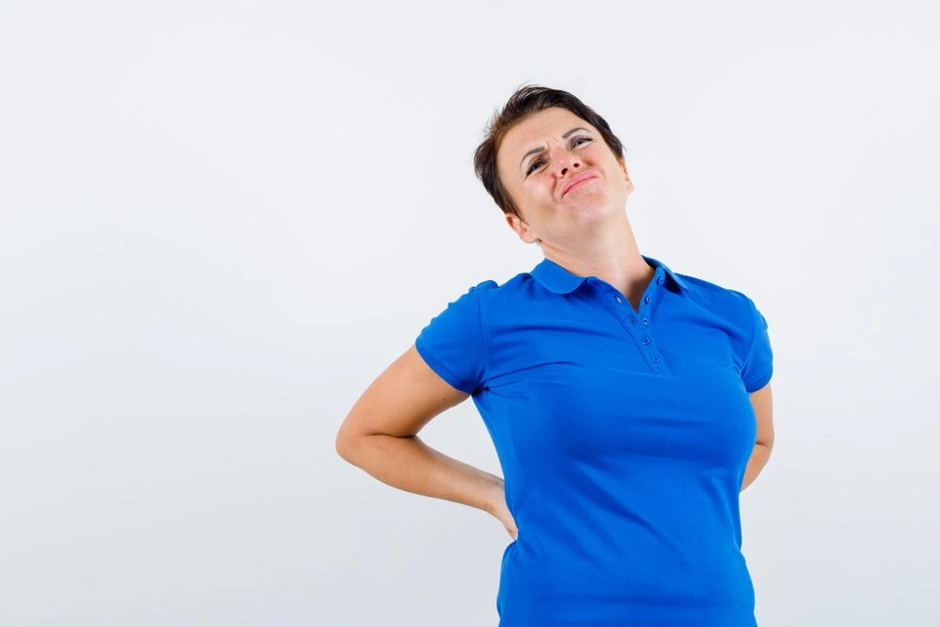 Woman holding her back in pain from chronic back pain