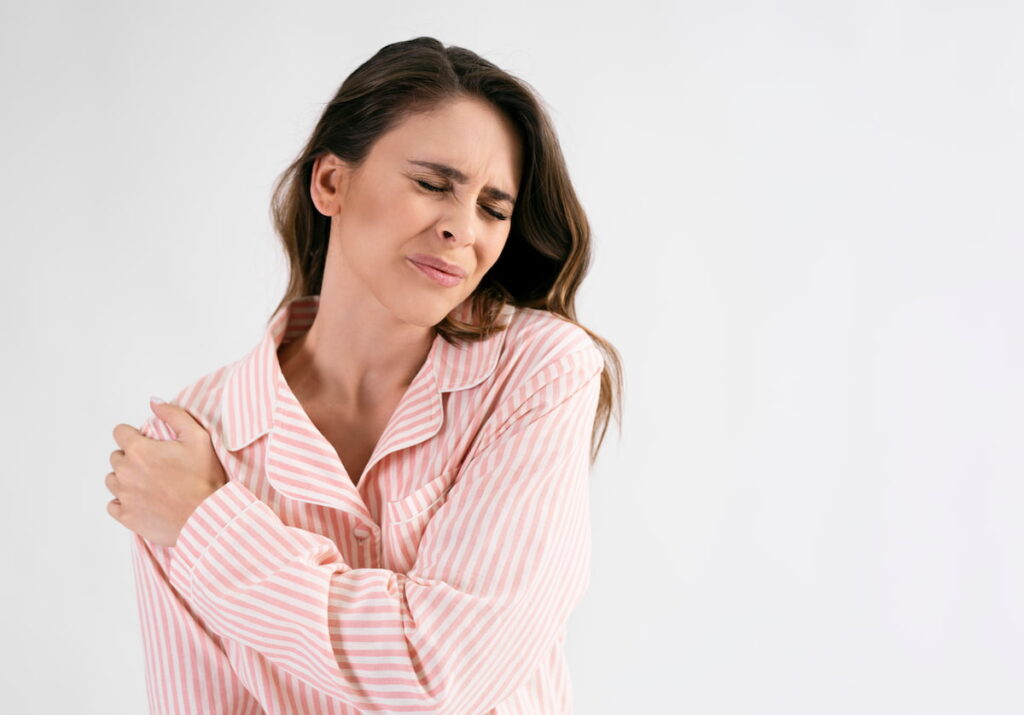 Woman holding her shoulder in pain