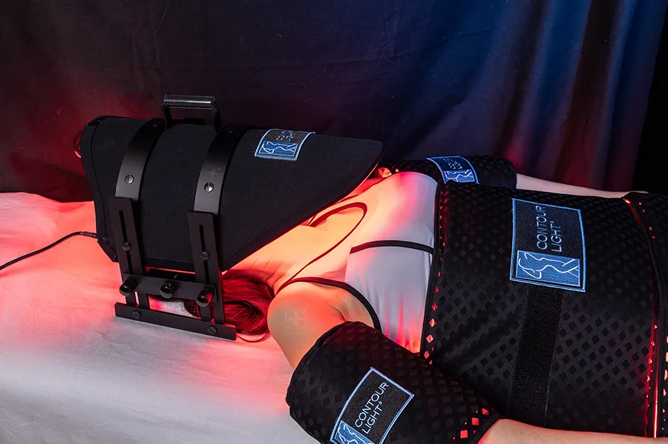 Contour light therapy device on female chiropractic patient