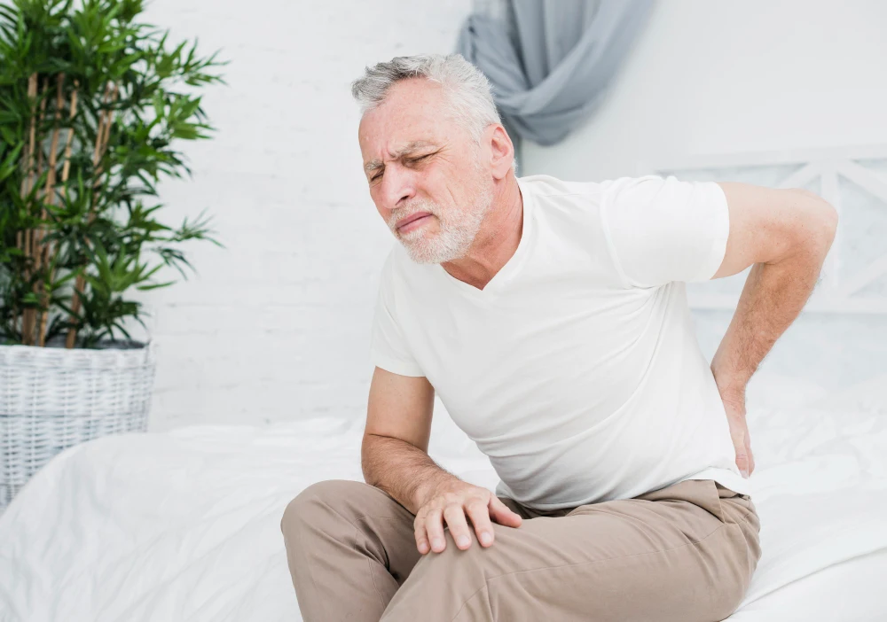 Elderly man experiencing herniated disc pain in lower back