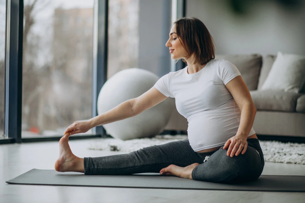 Pregnant woman performing gentle stretching exercise for pain relief